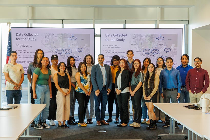 Men and women standing in front of whiteboard smiling.